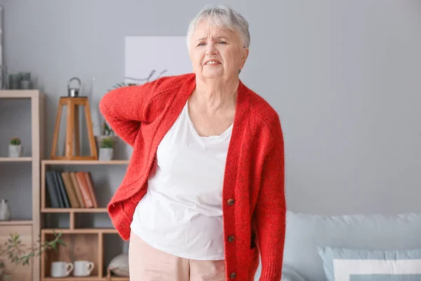 Senior woman suffering from back pain at home — Stock Photo, Image