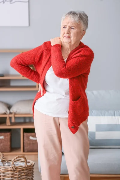 Senior woman suffering from pain in shoulder at home — Stock Photo, Image