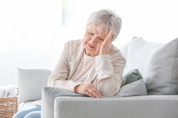 Старша жінка, що страждає від головного болю вдома — стокове фото