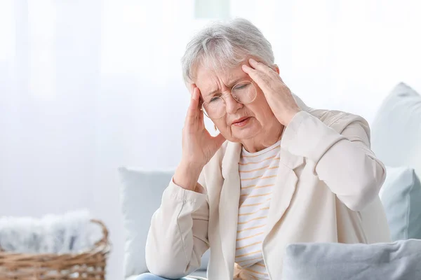 Oudere vrouw die thuis hoofdpijn heeft — Stockfoto