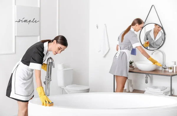 Beautiful chambermaids cleaning hotel bathroom — Stock Photo, Image