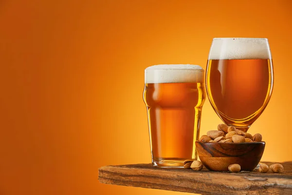 Bril bier en snack op tafel tegen een achtergrond van kleur — Stockfoto