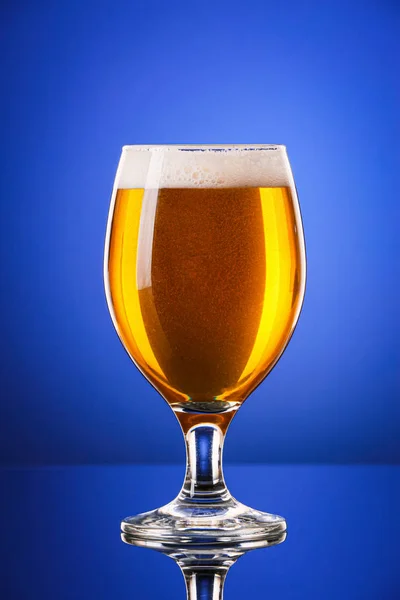 Glas av färsk öl på färg bakgrund — Stockfoto