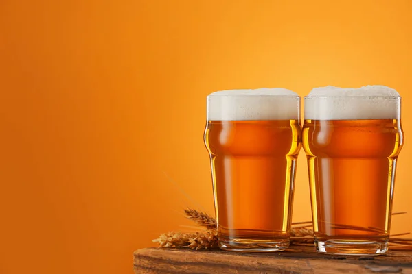 Bril bier op tafel tegen een achtergrond van kleur — Stockfoto