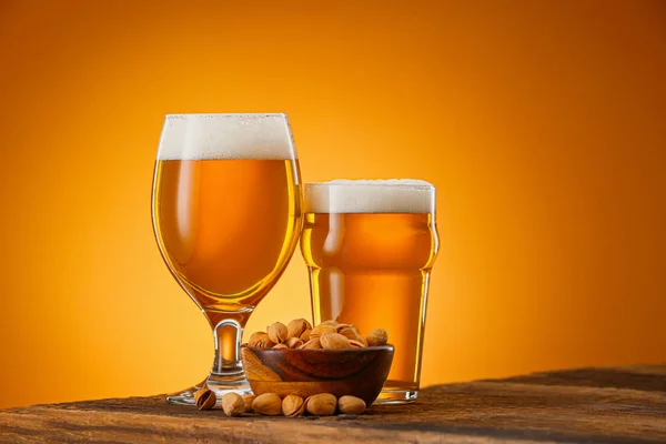 Bril bier en snack op tafel tegen een achtergrond van kleur — Stockfoto