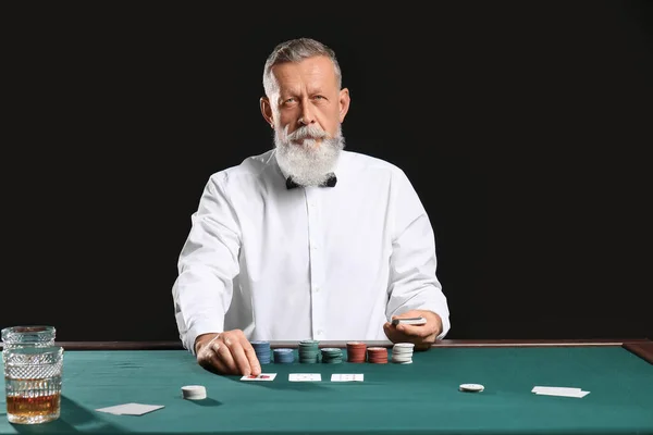 Starší muž bankéř u stolu v kasinu — Stock fotografie