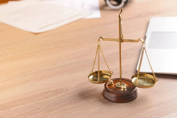 Scales of justice with laptop on lawyer's workplace — Stock Photo, Image