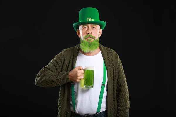 Funny mature man with glass of beer on dark background. St. Patrick's Day celebration — ストック写真
