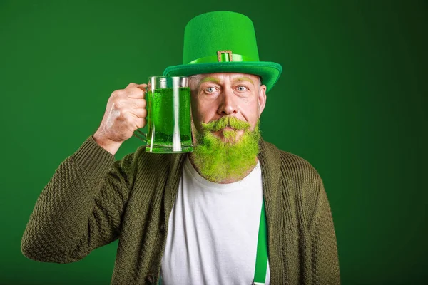 Grappige volwassen man met een glas bier op donkere achtergrond. St. Patrick 's Day viering — Stockfoto