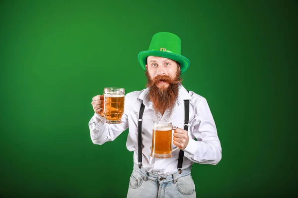 Bärtiger Mann mit Biergläsern auf farbigem Hintergrund. St. Patrick 's Day Feier — Stockfoto
