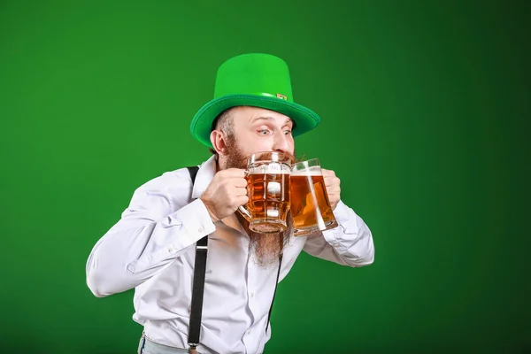 Bärtiger Mann mit Biergläsern auf farbigem Hintergrund. St. Patrick 's Day Feier — Stockfoto