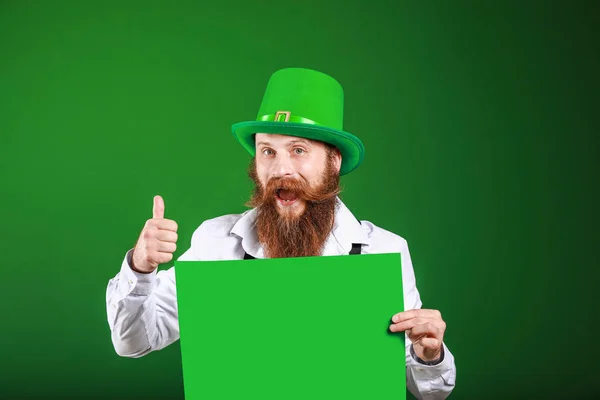 Bearded man with blank poster showing thumb-up gesture on color background. St. Patrick's Day celebration — ストック写真
