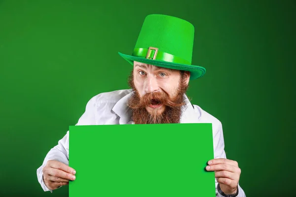 Bearded man with blank poster on color background. St. Patrick's Day celebration — ストック写真