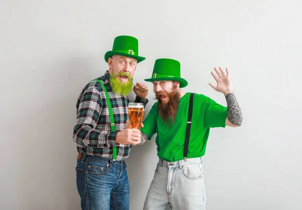 Baard mannen met een glas bier op een lichte achtergrond. St. Patrick 's Day viering — Stockfoto