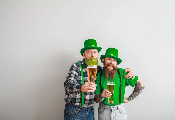 Bärtige Männer mit Biergläsern auf hellem Hintergrund. St. Patrick 's Day Feier — Stockfoto