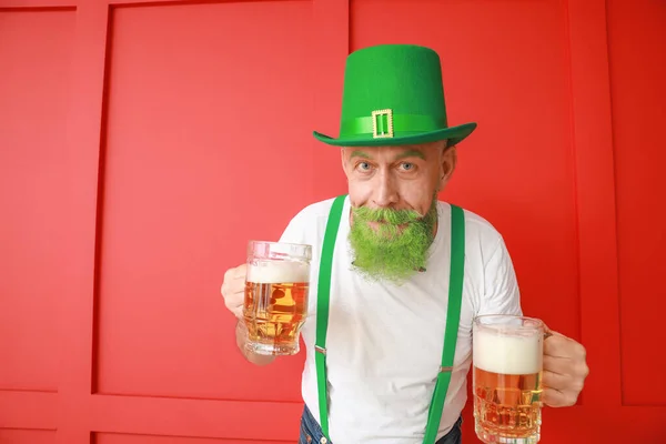 Funny mature man with glasses of beer on color background. St. Patrick's Day celebration — 스톡 사진
