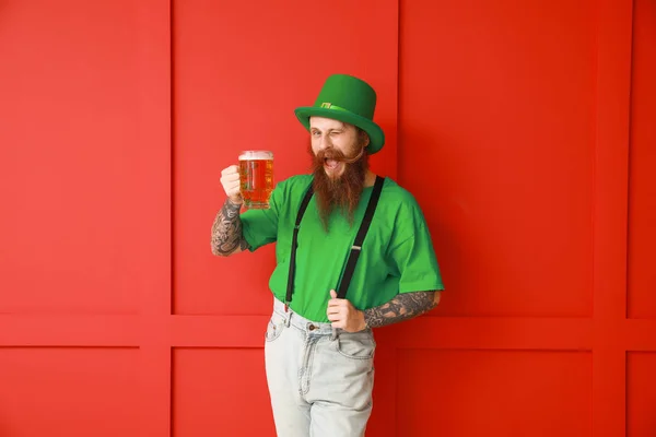 Homem barbudo com copo de cerveja no fundo de cor. Celebração do Dia de São Patrício — Fotografia de Stock