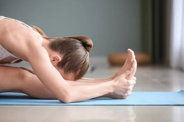 Mulher bonita praticando ioga em casa — Fotografia de Stock