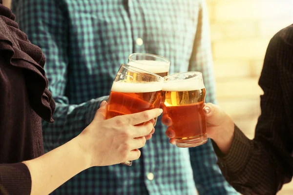 Gente tintineando vasos de cerveza en el interior —  Fotos de Stock