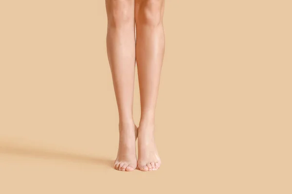 Beine der schönen jungen Frau auf farbigem Hintergrund — Stockfoto