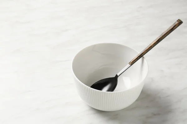 Empty bowl and spoon on light background — Stock Photo, Image