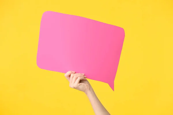 Mano femminile con bolla discorso vuoto su sfondo di colore — Foto Stock