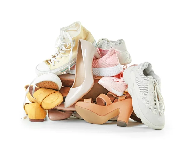 Tas de différentes chaussures sur fond blanc — Photo