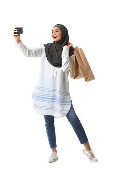漂亮的阿拉伯女人，提着购物袋带着白色背景的自拍 — 图库照片