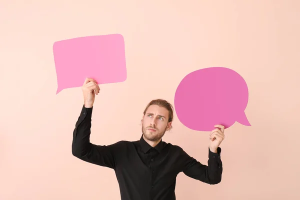 Jeune homme avec différentes bulles de parole vierges sur fond de couleur — Photo