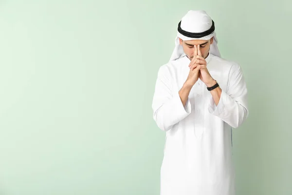 Bonito homem árabe orando no fundo da cor — Fotografia de Stock