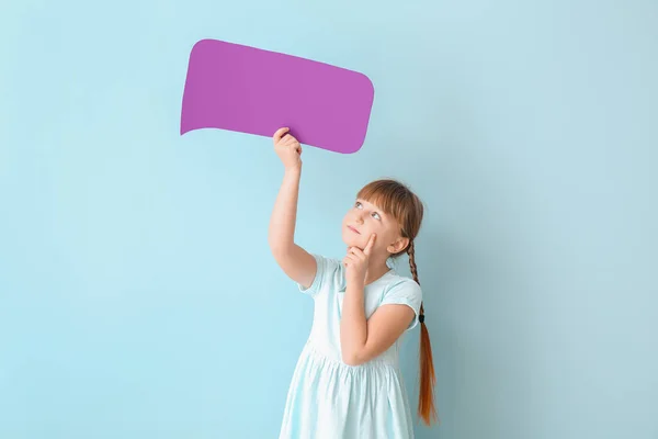 Cute little girl with blank speech bubble on color background — Stock Photo, Image