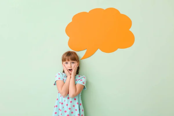 Surprised little girl with blank speech bubble on color background — Stock Photo, Image