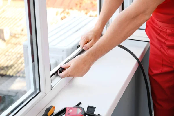Mężczyzna pracownik montaż okno w mieszkanie — Zdjęcie stockowe