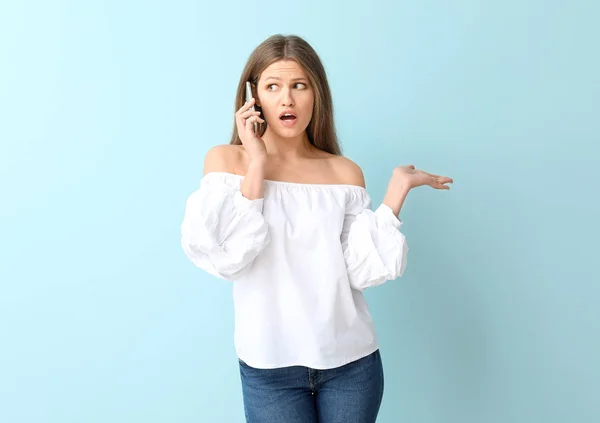 Problem kvinna talar med mobiltelefon på färg bakgrund — Stockfoto
