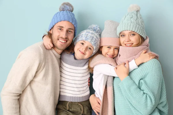 Lycklig familj i vinter kläder på färg bakgrund — Stockfoto