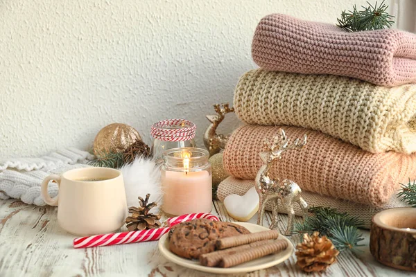 Kerstcompositie met snoep en winterkleding op tafel — Stockfoto
