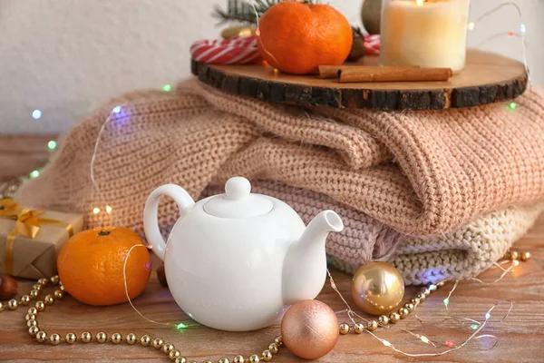 Christmas composition with teapot and winter clothes on table — Stock Photo, Image