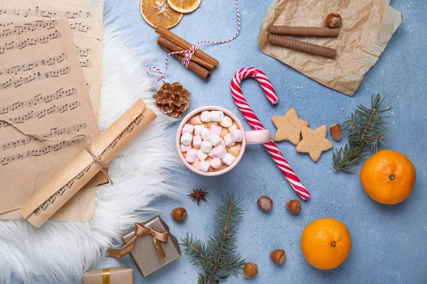 Renkli arka planda bir fincan sıcak çikolata ve müzik kağıtlarıyla Noel kompozisyonu — Stok fotoğraf