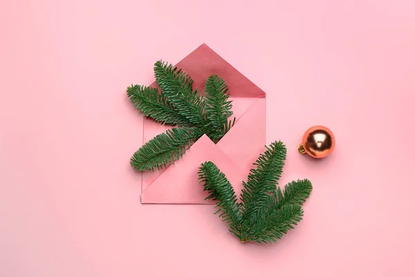 Envelop met sparren takken en kerstbal op kleur achtergrond — Stockfoto