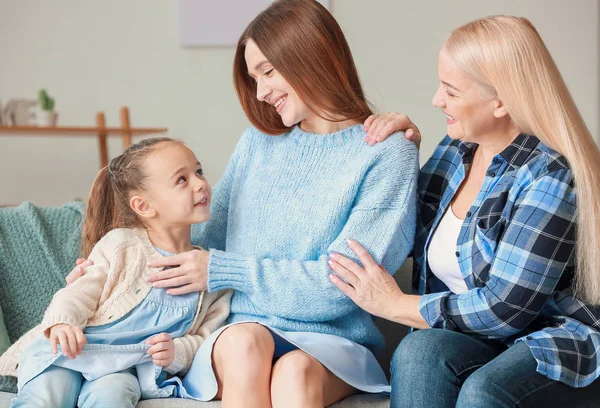 Young woman with her little daughter and mother spending time together at home — Stock Photo, Image