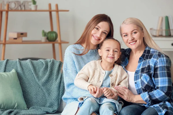 Jonge vrouw met haar kleine dochter en moeder brengen tijd samen door thuis — Stockfoto