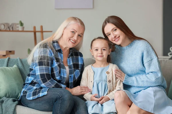 Jonge vrouw met haar kleine dochter en moeder brengen tijd samen door thuis — Stockfoto