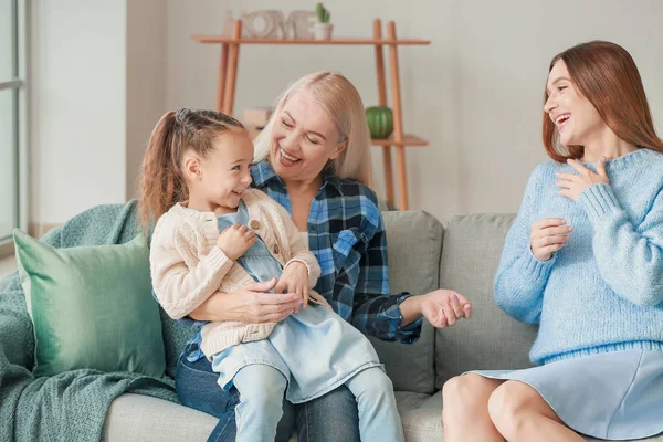 Jonge vrouw met haar kleine dochter en moeder brengen tijd samen door thuis — Stockfoto