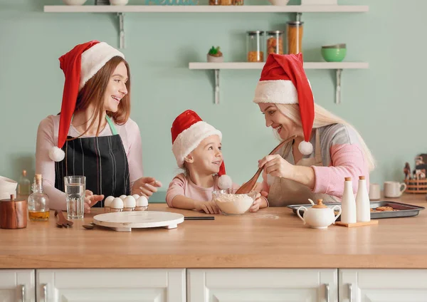 Jovem com sua filhinha e mãe cozinhar biscoitos de Natal em casa — Fotografia de Stock