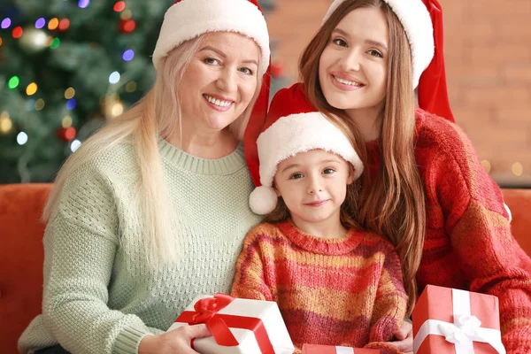 Young woman, her little daughter and mother with Christmas gifts at home — Stock Photo, Image