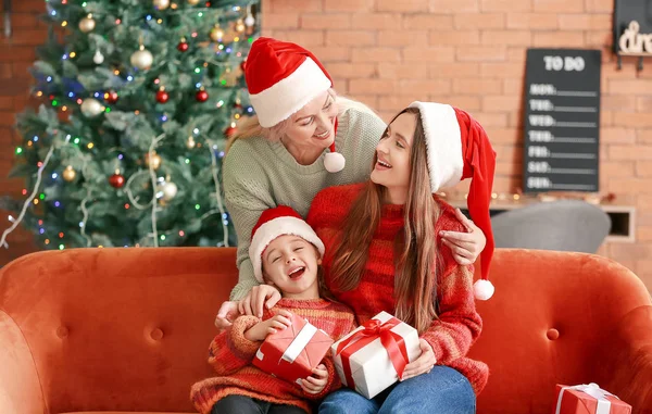 Giovane donna, la sua piccola figlia e madre con regali di Natale a casa — Foto Stock