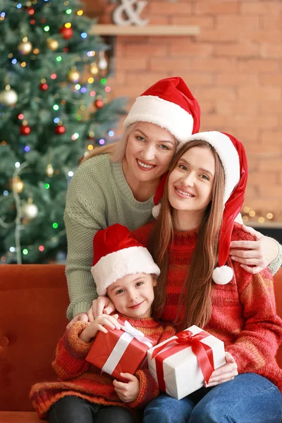 Young woman, her little daughter and mother with Christmas gifts at home — Stock Photo, Image