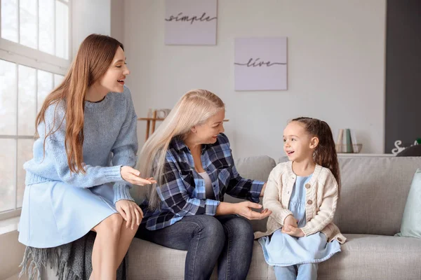 Young woman with her little daughter and mother spending time together at home — Stock Photo, Image