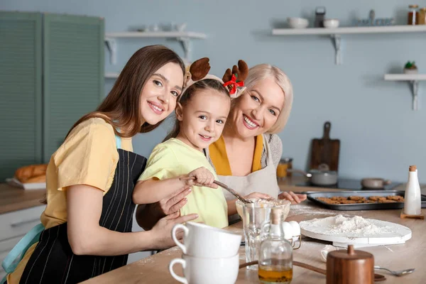 Jeune femme avec sa petite fille et sa mère cuisinant des biscuits de Noël à la maison — Photo