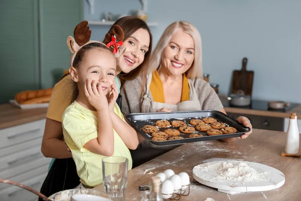 Young woman with her little daughter and mother cooking Christmas cookies at home — Stock Photo, Image